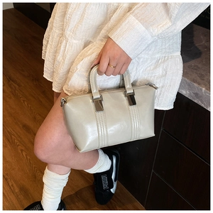 Detailed close-up of beige PU leather mini tote bag with vertical stitching and metal zip