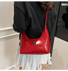 Detail of red patent leather hobo bag featuring a silver rectangular twist lock closure