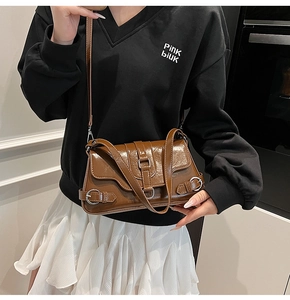 Détail du sac sous le bras rétro marron foncé en cuir brillant avec boucles argentées