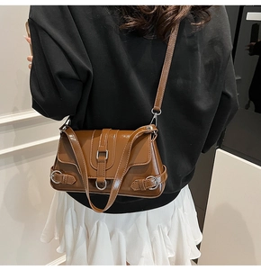 Détail d'un sac à bandoulière en cuir PU marron brillant avec boucle et anneaux argentés