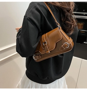 Détail d'un sac sous le bras vintage marron en similicuir avec boucles métalliques décoratives