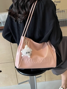 Pink glossy PU leather tote bag with embossed logo and white plush monster charm