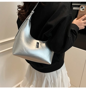 Detail view of silver metallic crescent hobo bag with sleek buckle and shoulder strap