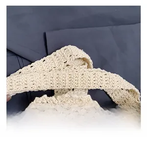 Nahaufnahme des Webriemens und der handgefertigten Textur dieser beigen Häkeltasche
