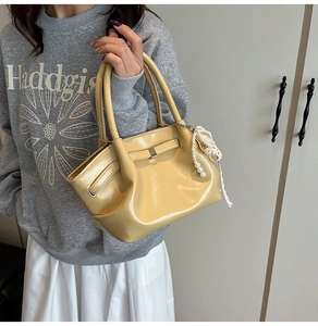 Detailansicht der hellgelben Handtasche mit weißem Perlenband und Spitzen-Schleife