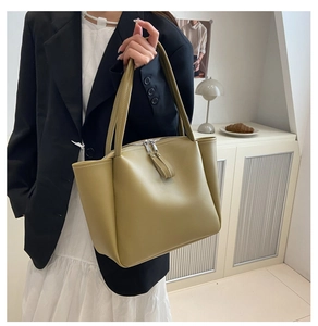 Detail view of olive green tote bag with contrasting white stitching and dual zippers