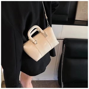 Detail of cream mini Boston bag with parallel stitching and round leather handles