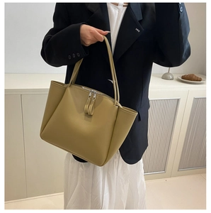 Detail view of large tote bag with contrast stitching and long leather zipper pulls