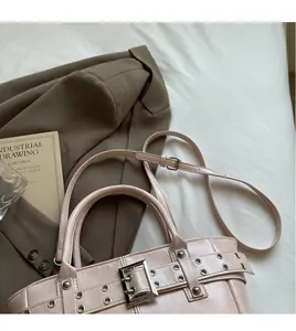 Dettaglio della borsa tote in pelle rosa chiaro con tracolla regolabile e liscia