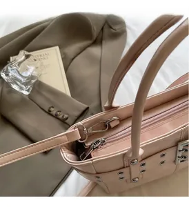 Dettaglio della borsa tote rosa con fibbie metalliche argentate e tracolla regolabile