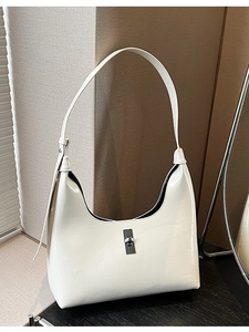 Elegant cream patent leather hobo bag with silver rectangular clasp and adjustable strap