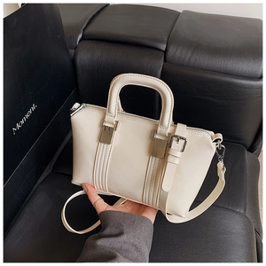 Close-up of cream mini handbag with textured synthetic leather and silver hardware