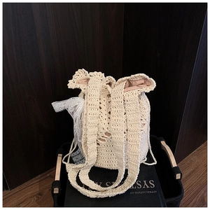 Macro view of woven straw bucket bag showing lace mesh detail and crochet texture