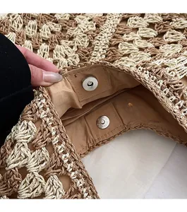 Détail de la fermeture à boucle magnétique sur un sac cabas tissé beige et marron