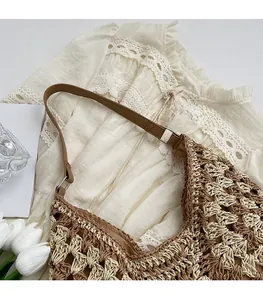 Gros plan sur le sac tissé avec motif en losanges et bandoulière en cuir marron