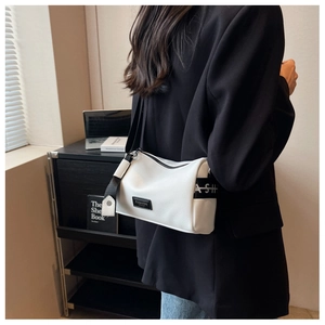Gros plan sur la texture grainée blanche et le logo de mode sur le sac Boston