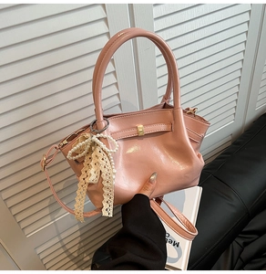 Rosa Vintage-Handtasche mit Perlen-Bogen-Anhänger auf Ledersofa