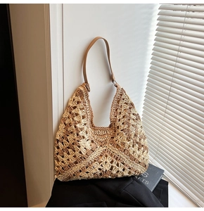 Détail du sac à bandoulière en paille tressée avec sangle en cuir et boucle métallique