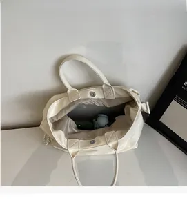 Detail view of large white oil wax leather tote interior with magnetic metal closure