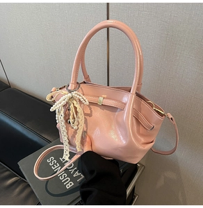 Detail der rosa Lackleder-Handtasche mit Perlen-Spitzen-Anhänger und Trageriemen
