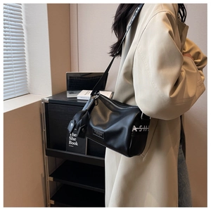 Détail du sac polochon noir avec sa large bandoulière tendance ornée de lettrage blanc