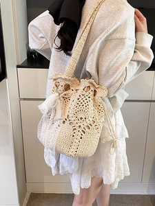 Handmade woven straw bucket bag with delicate lace and pearl tassel for beach vacations