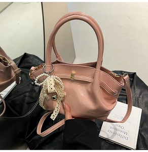 Detail der hellrosa Handtasche mit Perlen-Spitzen-Anhängern und mattem Finish