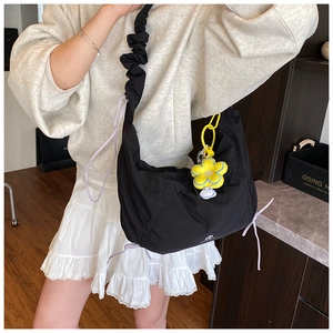 Détail du sac nuage noir plissé avec cordons violets et breloque fleur jaune