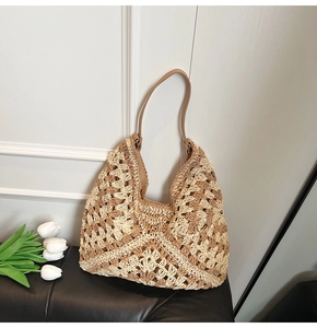 Détail d'un sac hobo au crochet avec motifs floraux ajourés et bandoulière en cuir