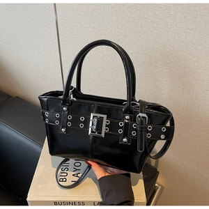 Dettaglio della borsa punk nera lucida con cinturini con occhielli argentati e fibbie