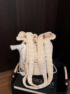 Handwoven cream bucket bag with lace ribbon detail for summer beach and vacation styling