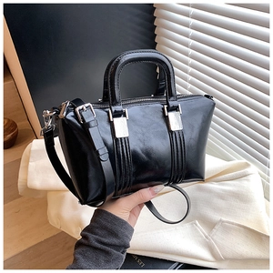 Detailed shot of a black oiled PU leather handbag featuring silver hardware accents