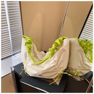 Détail du sac crème plissé avec bandoulière à volants vert fluo et cordon de serrage