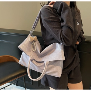 Lilac tote bag with pearl bow charm worn by model, showing stylish large capacity
