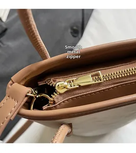 Gros plan sur la fermeture éclair dorée et les coutures du sac seau bicolore chic