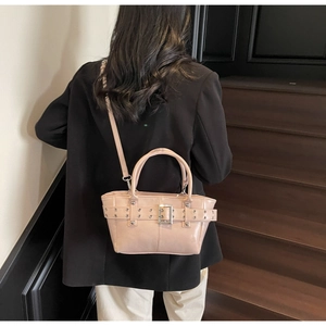 Vista dettagliata della borsa tote in pelle rosa con fibbia argento e borchie sul modello
