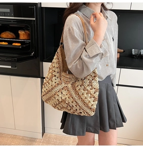 Détail du sac bandoulière en paille tressée aux motifs géométriques et sangle en cuir