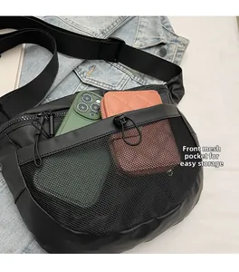 Détail d'un sac à bandoulière noir avec poche avant en filet et grande capacité de rangement