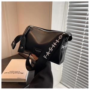 Détail du sac bandoulière en cuir noir avec large sangle en tissu imprimé 'FASHION'
