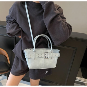 Dettaglio della borsa tote azzurra con occhielli metallici e fibbia decorativa rifinita