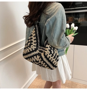 Détail du sac hobo tissé à la main avec motif damier et bandoulière en cuir noir sur modèle