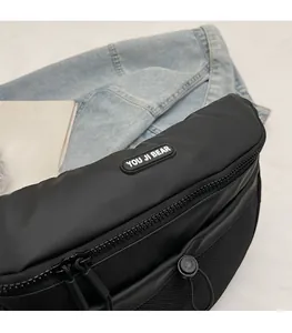 Détail du sac à bandoulière noir avec logo YOU JI BEAR et poche latérale en filet pratique