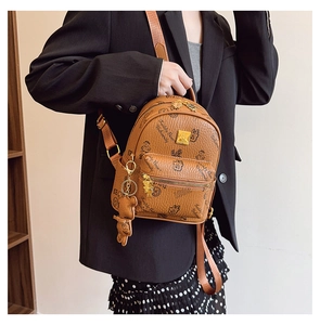 Detail of a brown mini backpack featuring teddy bear prints and a cute bear charm accessory