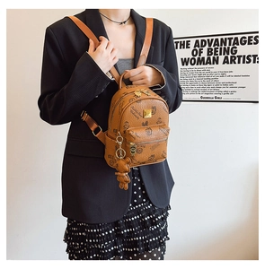 Detailed shot of a mini brown leather backpack with teddy bear prints and gold hardware