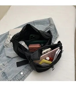 Détails intérieurs du sac bandoulière en nylon noir montrant une grande capacité de stockage