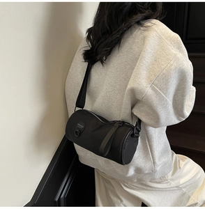Detail view of the black nylon cylinder bag showing the texture and adjustable strap