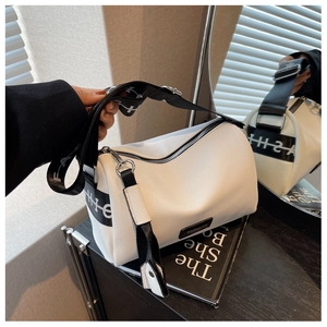 Gros plan sur le sac polochon en cuir blanc avec large bandoulière à lettres et logo