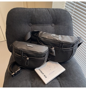 Détail de sacs banane en nylon noir imperméable avec poches en filet sur un fauteuil en velours
