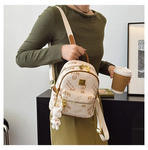 Detail of cream backpack with vintage bear print, brown trim, and cute teddy charm