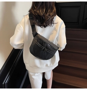 Détail du sac bandoulière noir avec poche avant en filet et sangle en nylon ajustable